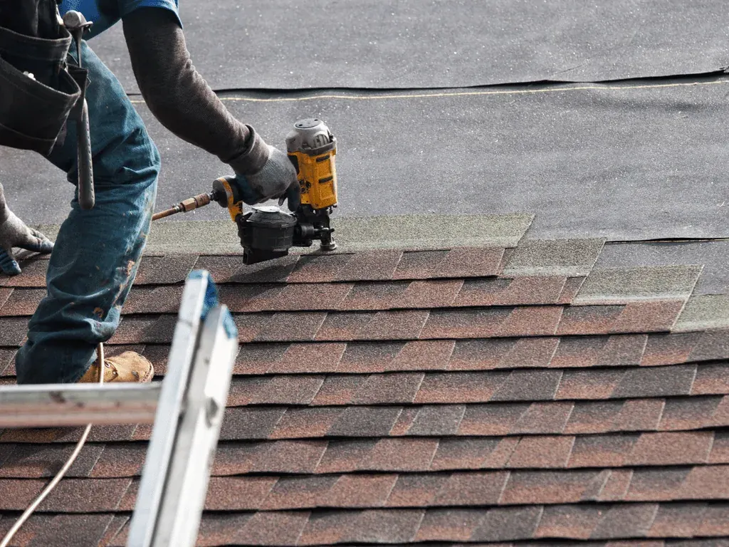 SCI Roofing technician fastening architectural shingles on a South Florida roof
